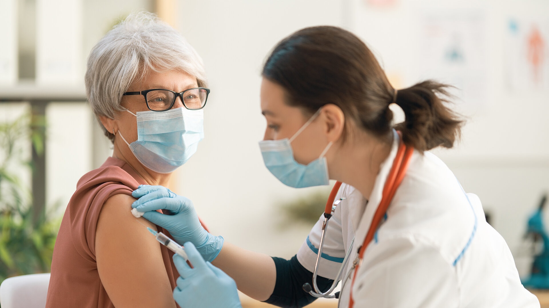 A nurse immunising an elderly woman in senior living