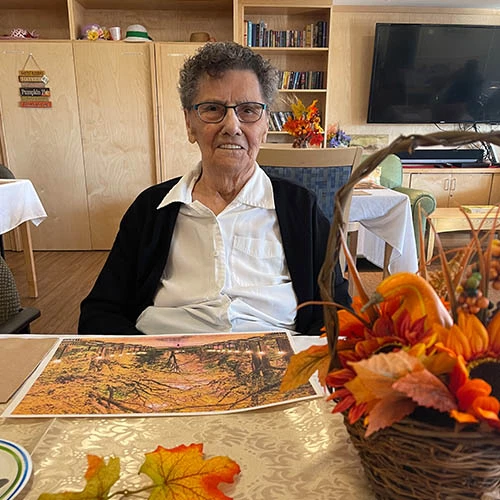 Resident smiling while seated at a table for Thanksgiving.