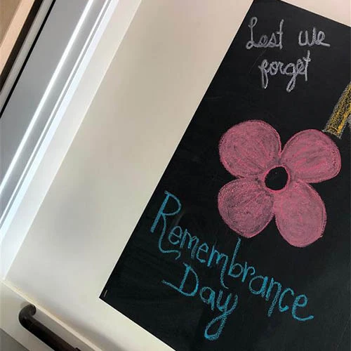 Poppy and beautifully handwritten Remembrance Day sign.