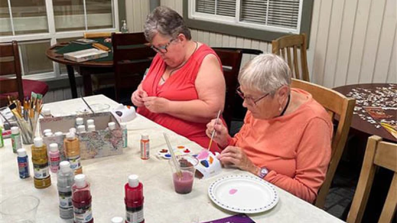 Residents painting masks together with pink, blue, and red paint.
