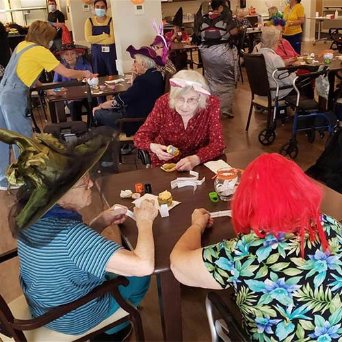 Residents enjoying halloween activities together at tables.