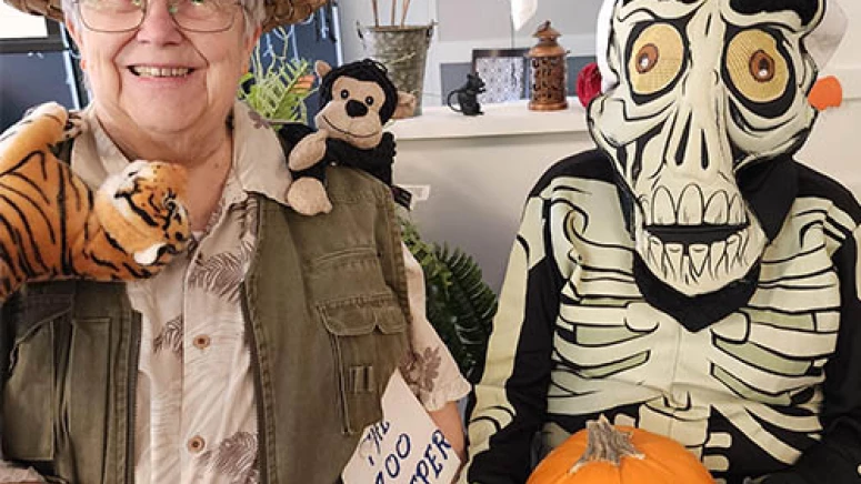 Residents dressed in halloween costumes. One is dressed as a zookeeper, the other as a skeleton.