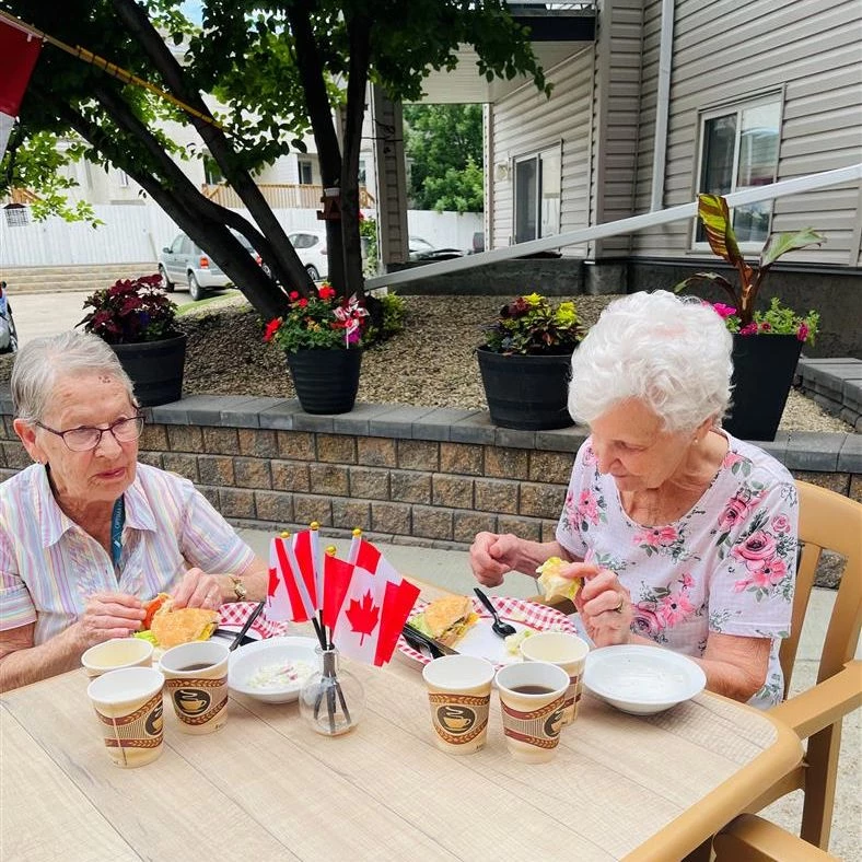 Seniors eating outside together while celebrating Canada Day.