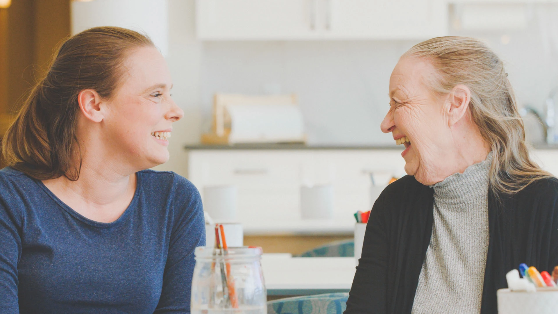 Senior woman laughing with a staff member