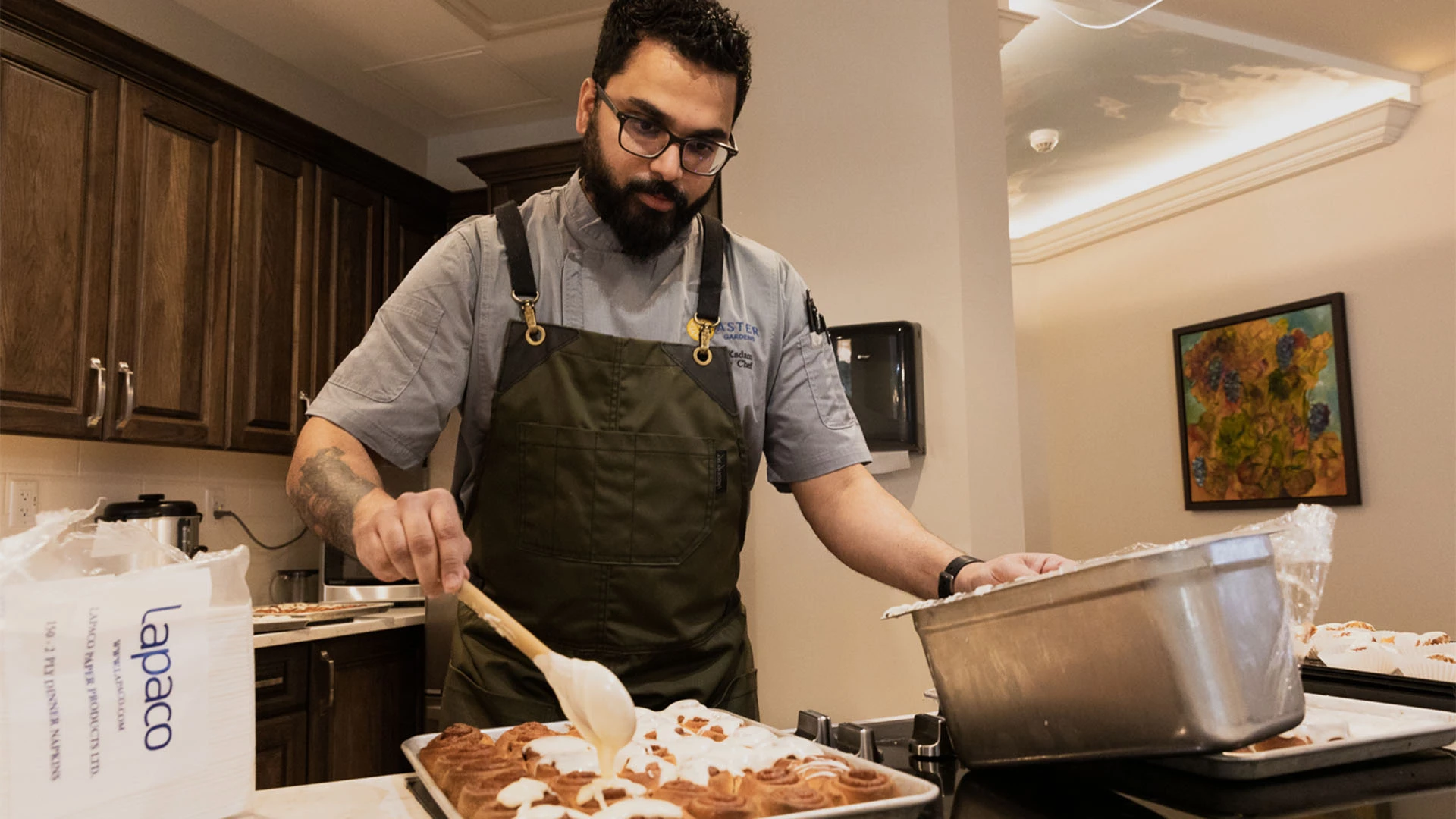 Aster Gardens chef preparing a tray of cinnamon buns
