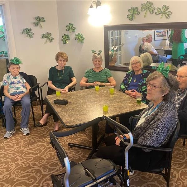 Seniors sitting around a table enjoying green drinks together for St. Patricks Day.