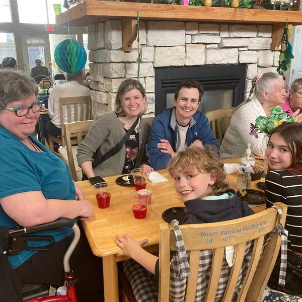 A smiling family enjoying juice and snacks at Norman Manor