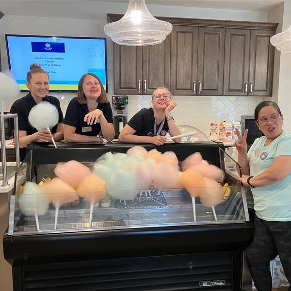 Staff members smiling and standing around cotton candy treats