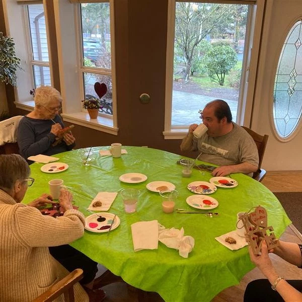 Seniors seated at a table participating in some Valentine's Day crafts.