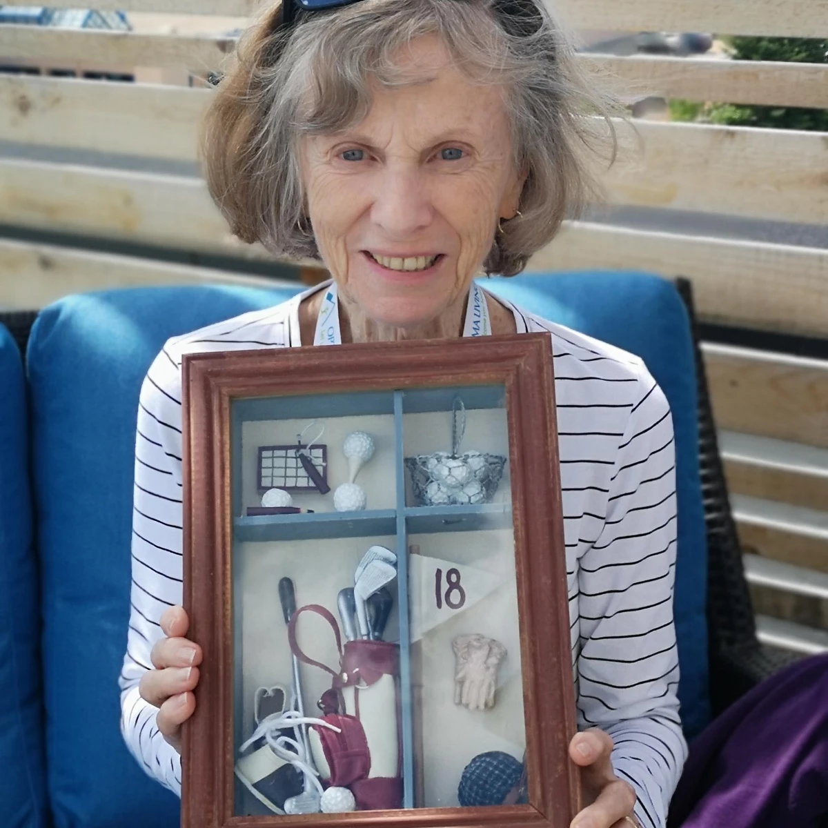 An elderly woman holding an antique frame