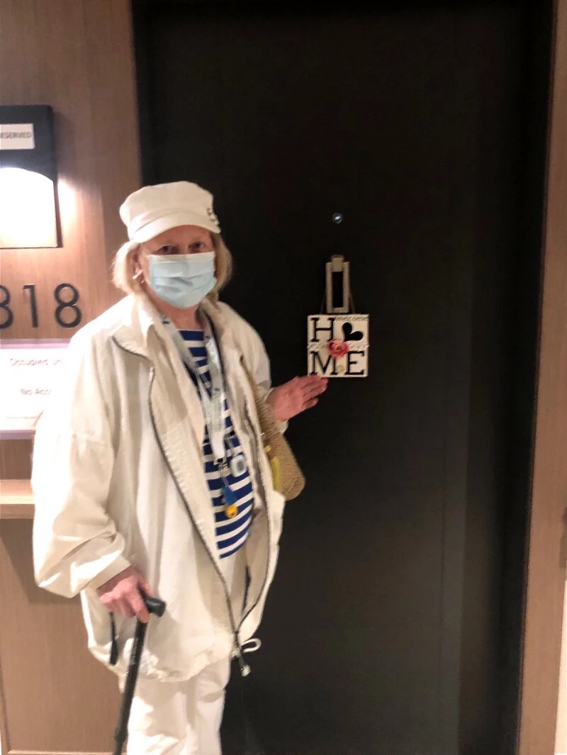 A senior lady standing in the door of her new home