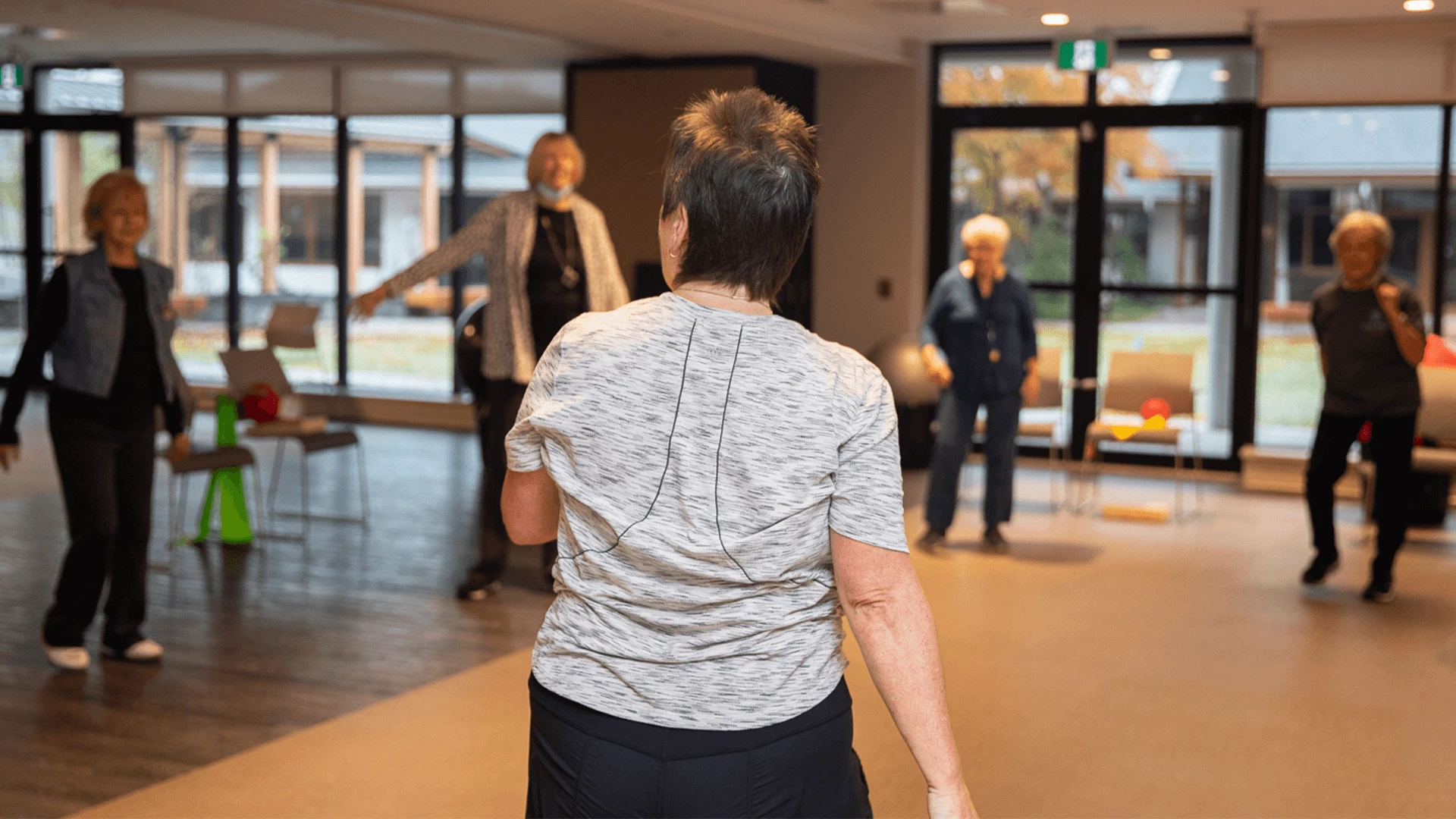 A lady teaching a fitness class to senior women