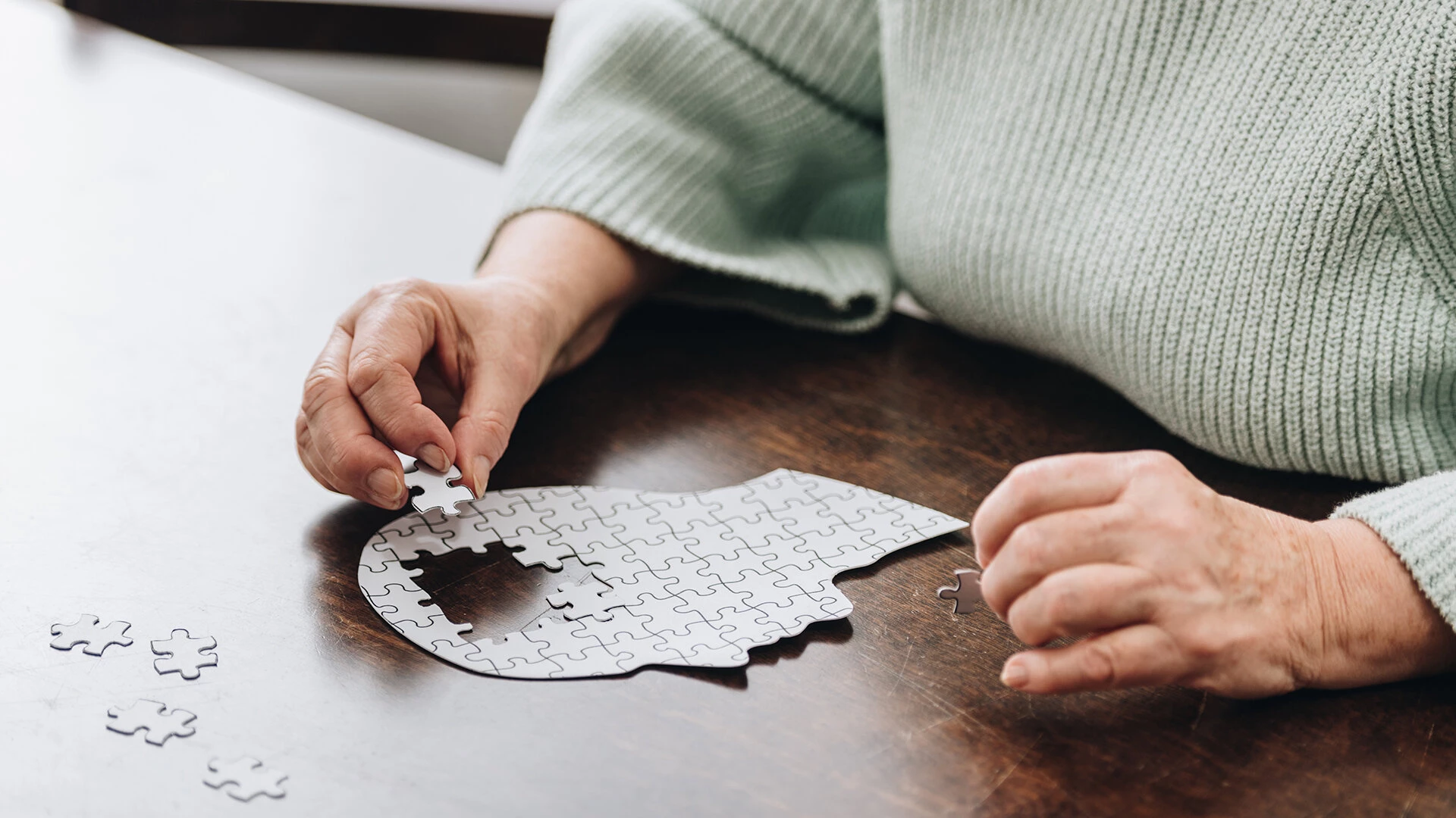 An elderly person solving a puzzle in senior apartments