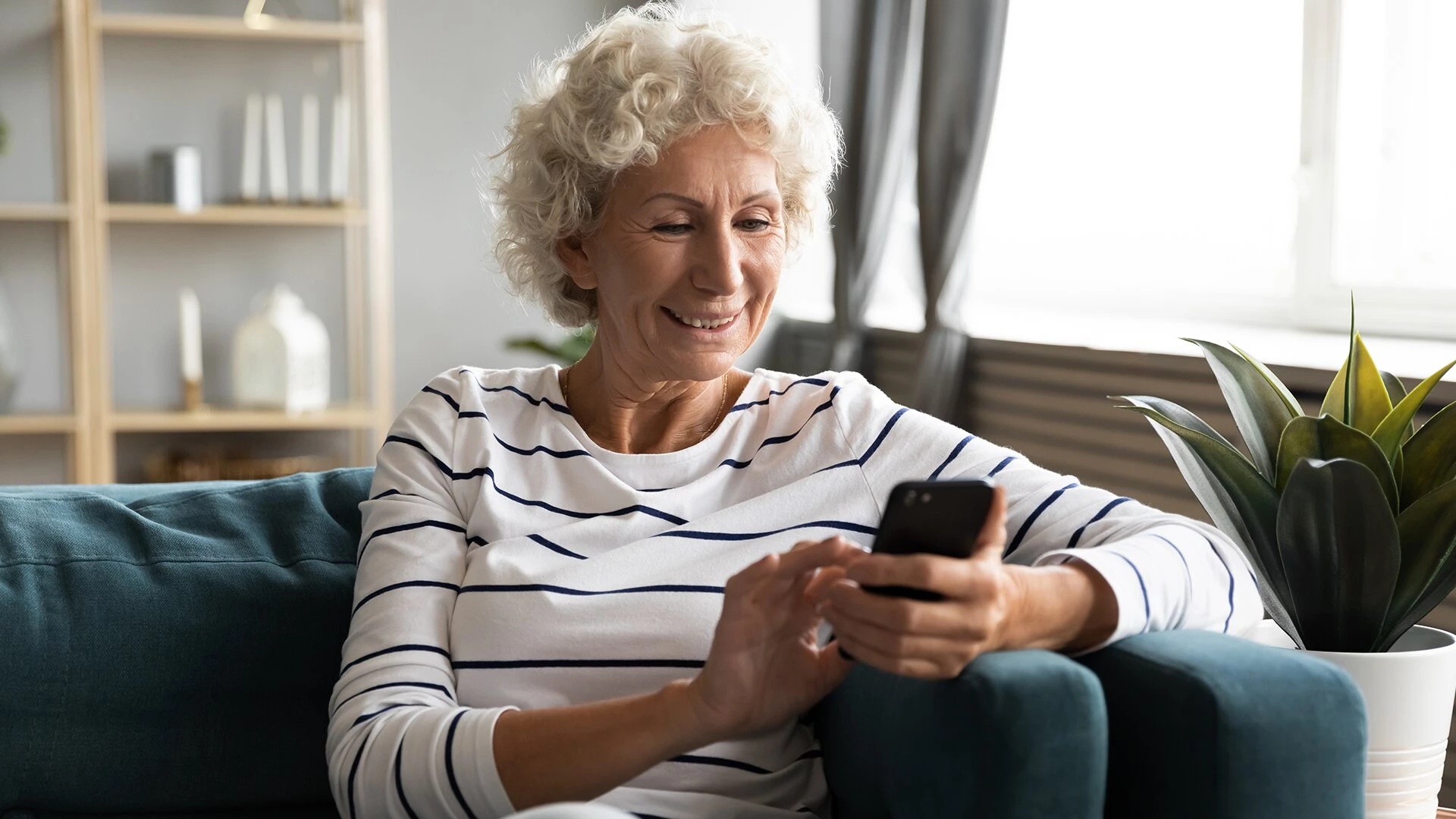 An older woman watching the Reimagining the Future of Later Life webinar in senior apartments