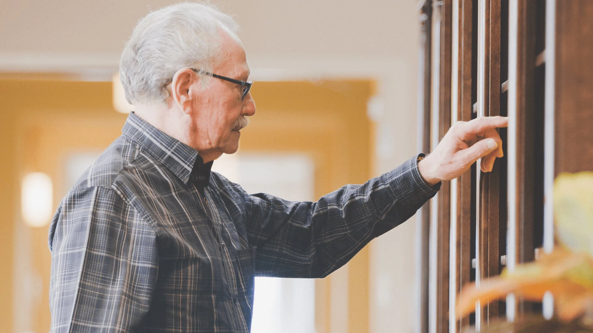 A senior citizen browsing the library of Aster Gardens