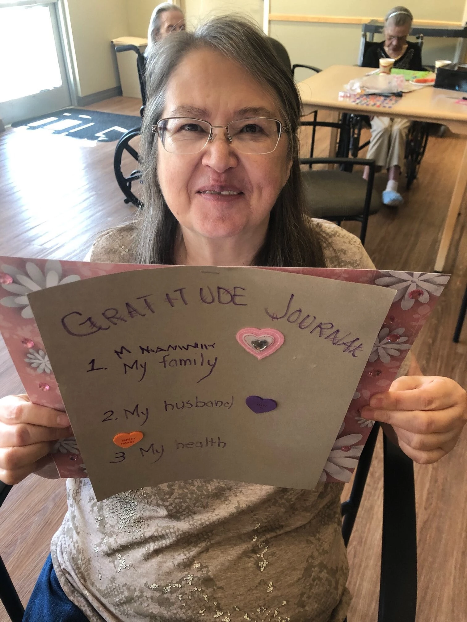 A senior lady holding a gratitude card