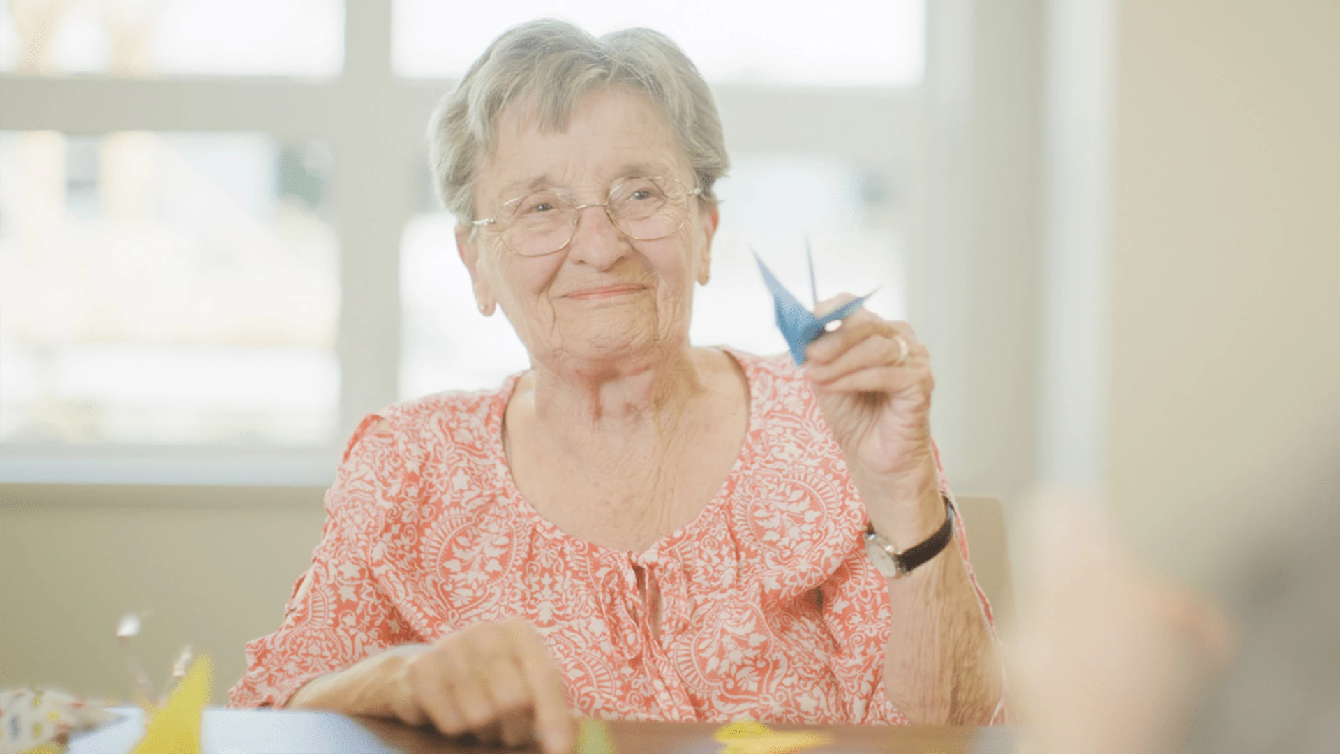 Senior lady holding a folded paper crane