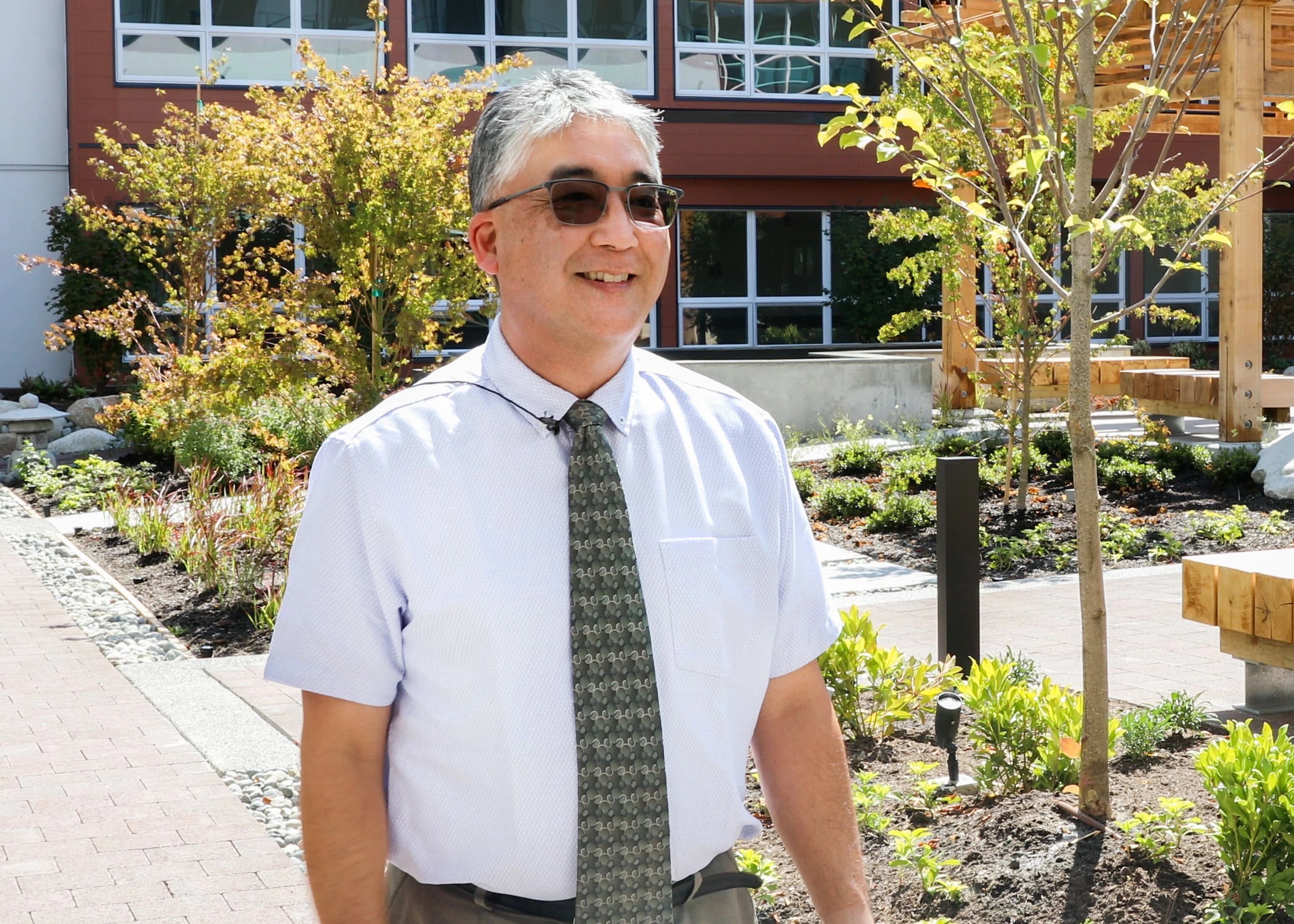 A man wearing glasses and standing in front of Wisteria place