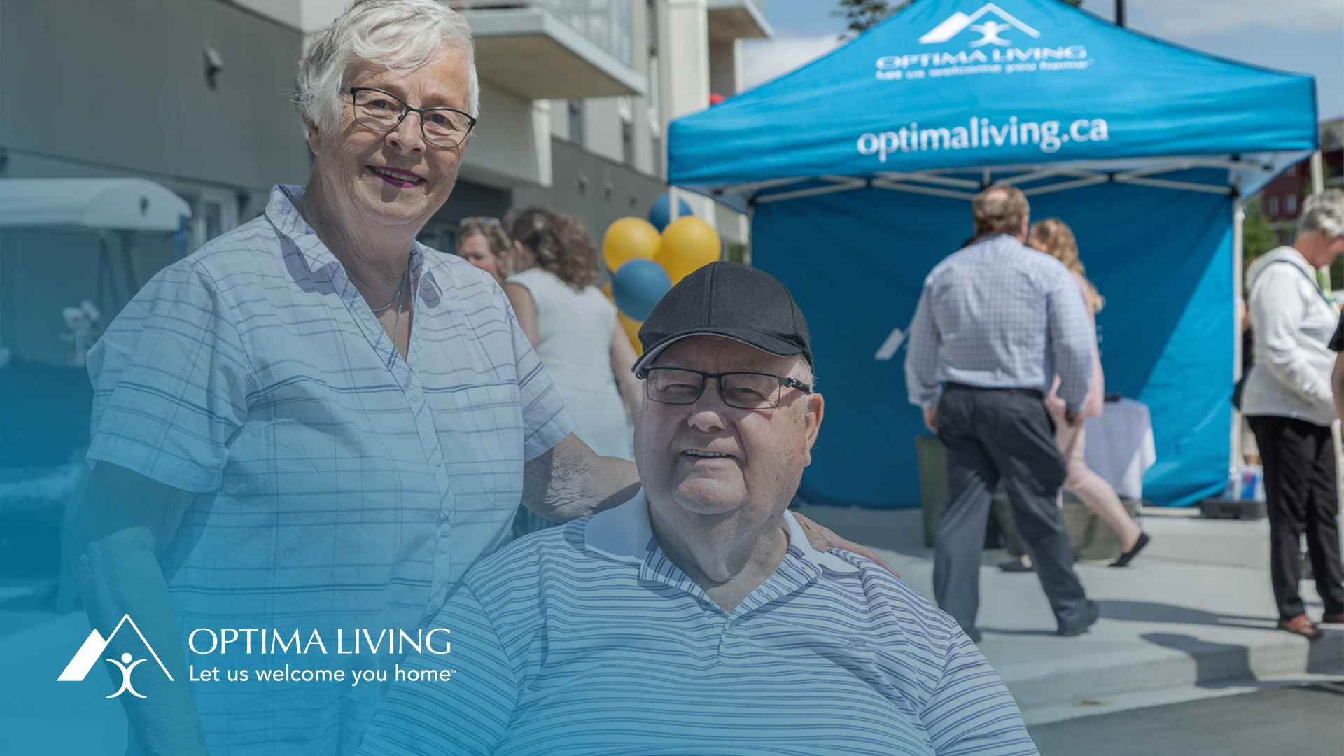 Male and female seniors with blue optima living tent behind them