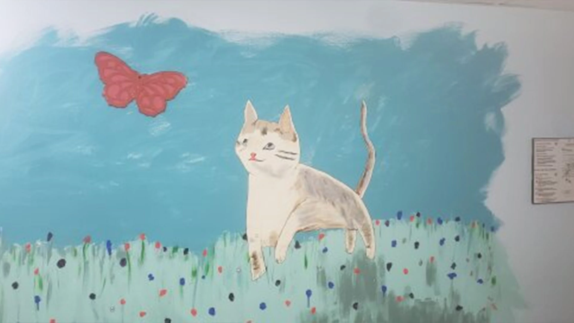 Painting of a cat and butterfly on the wall