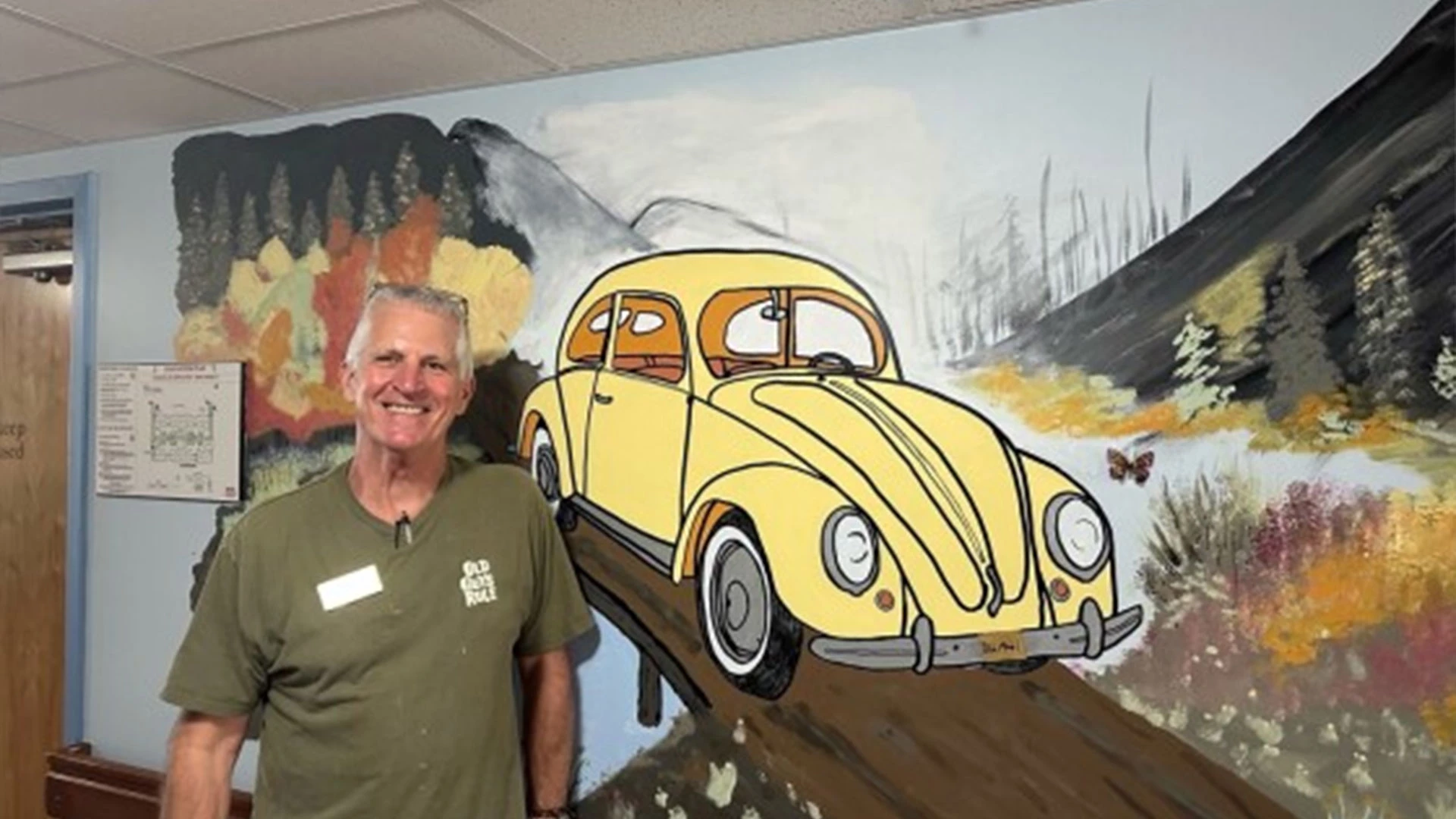 Man standing in front of a mural of an old VW