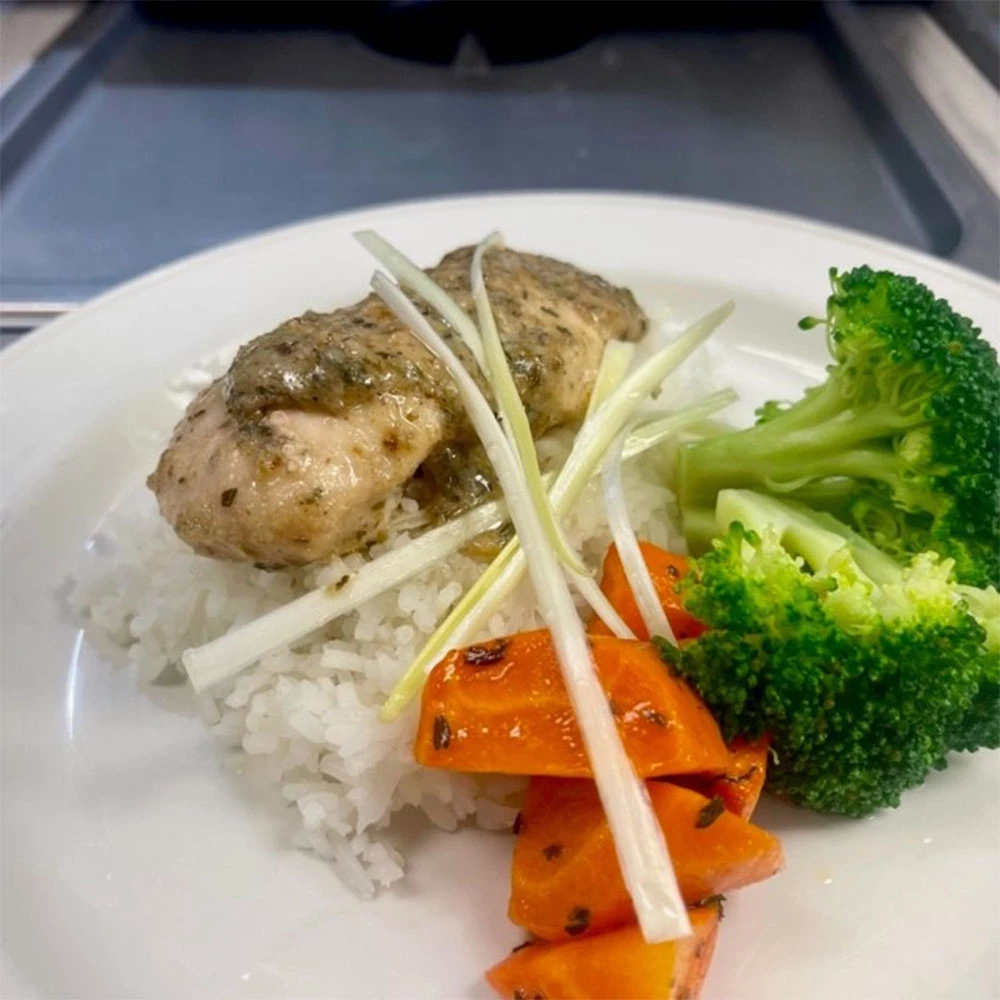A plate with chicken, rice, broccoli and carrots