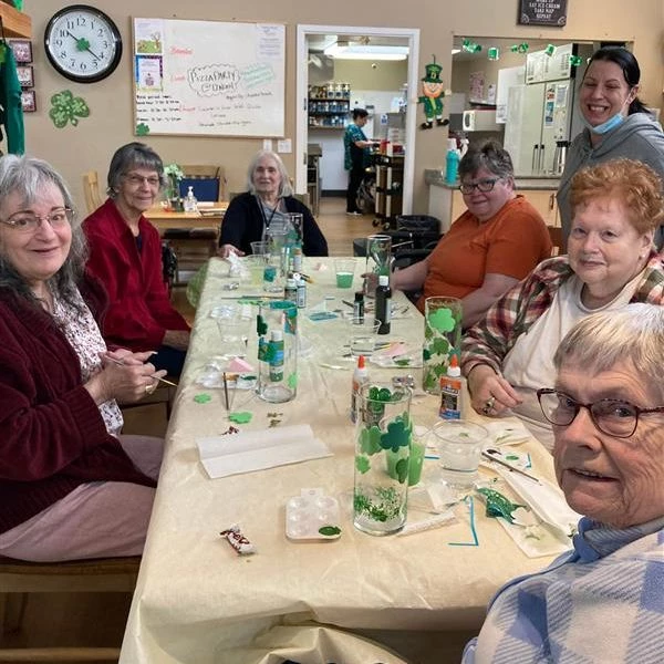 Seniors seated together making some St. Patrick's Day crafts.