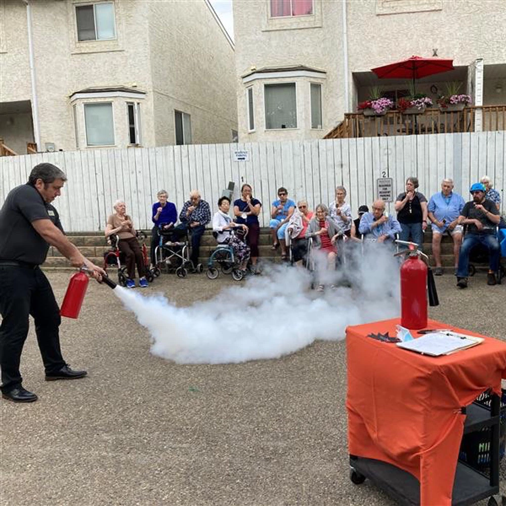 Fireman showing a crowd how to use a fire extinguisher