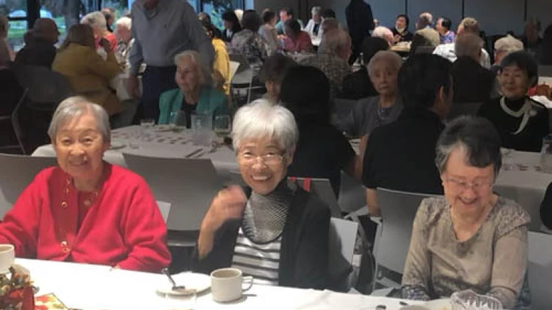 Residents enjoying Thanksgiving today together. Three women are smiling together at the first table.