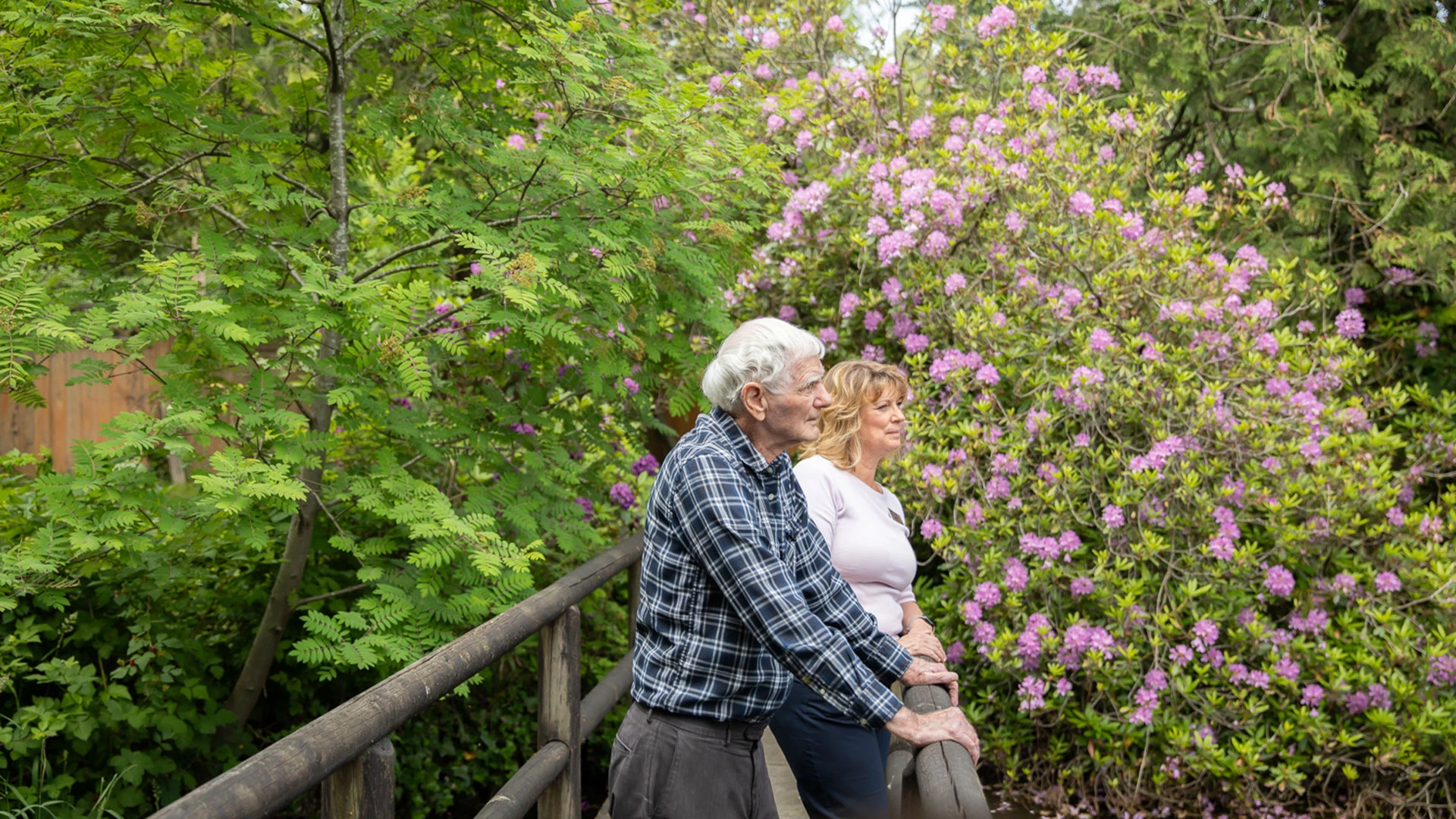 Senior standing on bridge in front of flowers