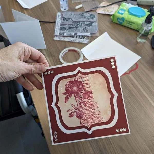 Decorated card with a rose and textured text behind it